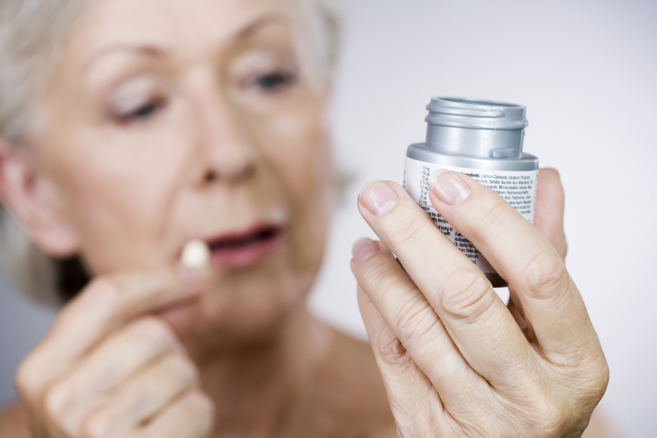 Senior woman holding a bottle of pills