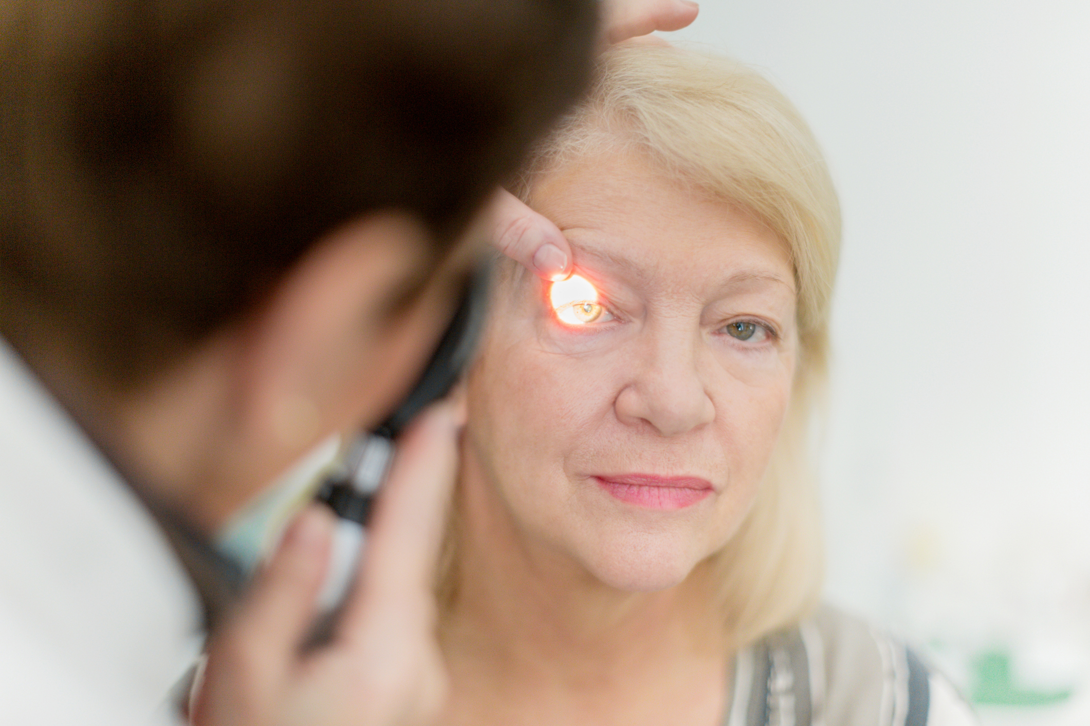 Eye doctor giving an older woman an eye exam