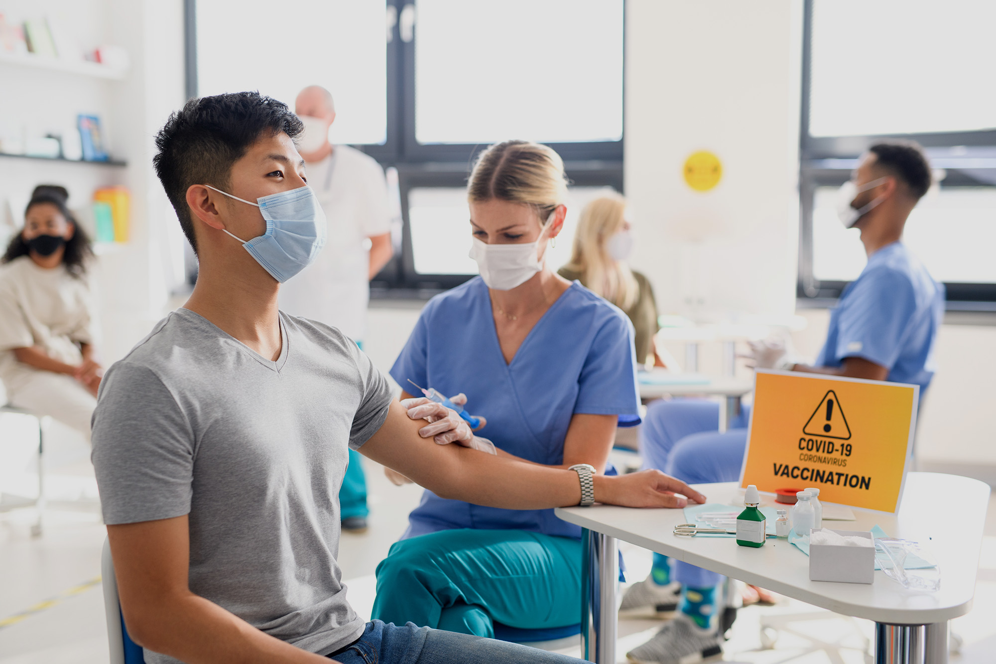 Man with facemask getting vaccinated at a clinic