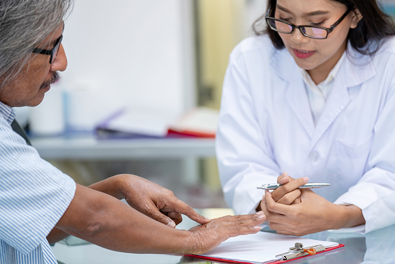 Man showing dry skin to his doctor.